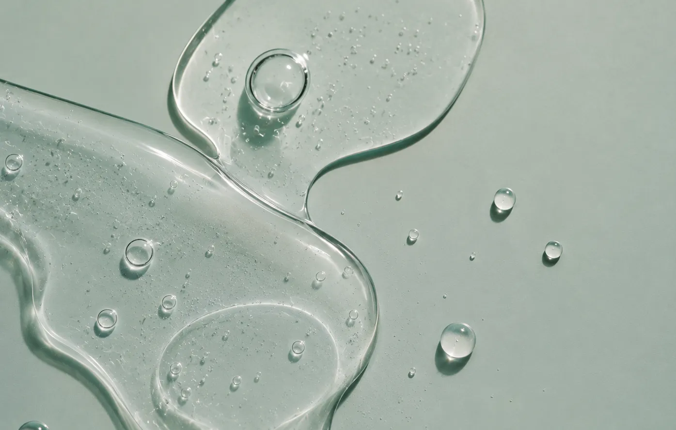 Skincare serum on a soft green surface